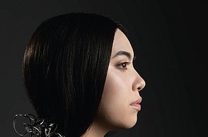 Foto einer Person mit einem Schmuckstück, dass von ihren Haaren auf ihre Schulter fällt