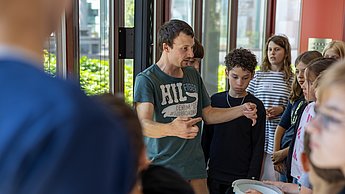 So werden Bienen gefüttert: Kinder sehen sich Kanister mit Zuckerwasser an.
