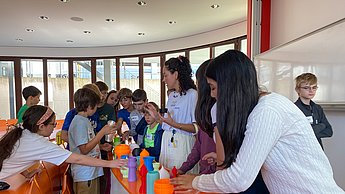 Kindergruppe schaut sich Lampenschirme aus dem 3D Druck an