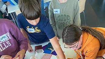 Kinder kleben mit Punkten Bilder von Einstein und Marie Curie