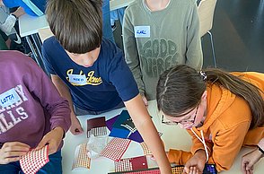 Kinder kleben mit Punkten Bilder von Einstein und Marie Curie
