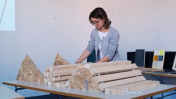 Studentin arbeitet mit Holzbalken