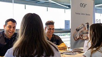 Personen an einem Tisch im Austausch