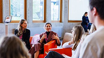 Frauen auf einem Sofas sitzend im Austausch 