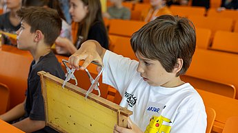 Kinder schauen sich Bienenwaben und Utensilien zur Imkerei an.