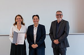 Gewinnerin, Moderatorin und Laudator bei der Preisverleihung