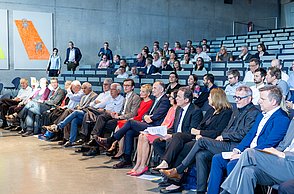 Menschen sitzen in einem Hörsaal.