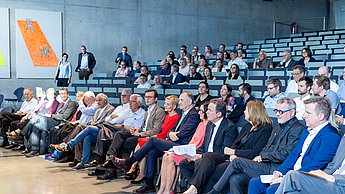 Menschen sitzen in einem Hörsaal.