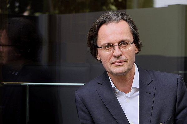 Mann mit Brille schaut in Kamera