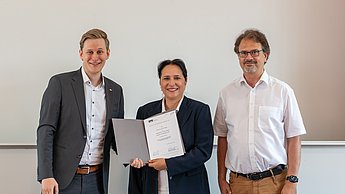 Gewinner, Moderatorin und Professor bei der Preisverleihung