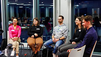Studierende im Gespräch in einem Stuhlkreis