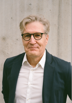 Älterer Herr mit Brille schaut in die Kamera.