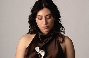 Foto einer Frau in einem Kleid, die eine kleine Kiste auf der Hand hält