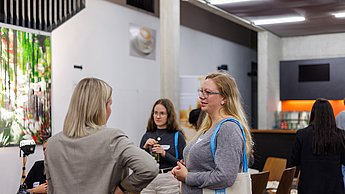 Studierende im Austausch mit Mitarbeiterin einer Firma