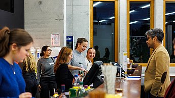 Ein Studierender an der Bar und Barpersonal, das Cocktails mixt
