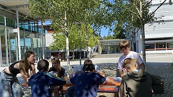 Kinder spielen Stille Post auf dem Campus der Hochschule Pforzheim