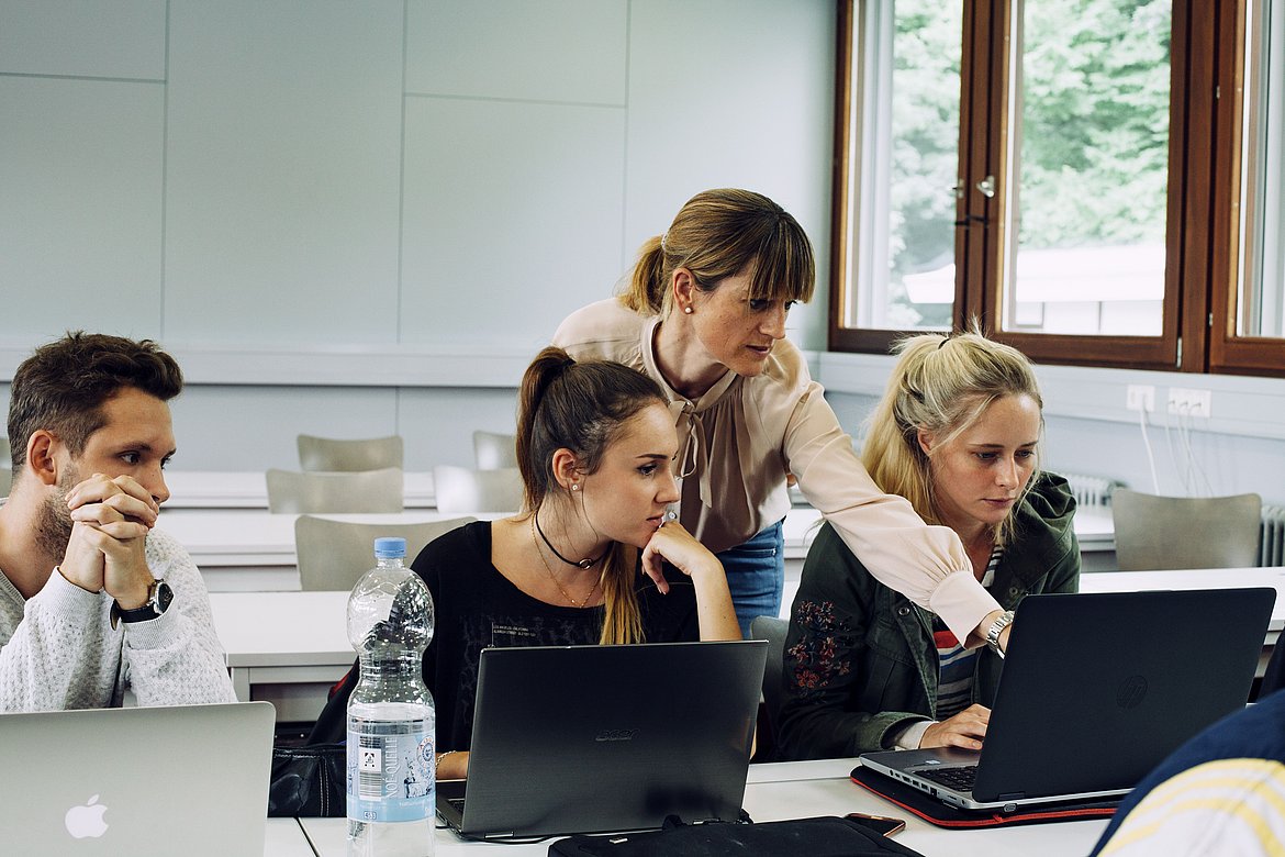 Prof. Dr. Yasmin Merz zeigt auf den Laptop einer Studierenden und erklärt