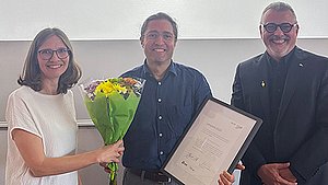 Preisträger Prof. Dr. Fernando Fastoso mit Urkunde und Blumenstrauß, links von ihm Prof. Dr. Anja Spilski, rechts Prof. Dr. Thomas Cleff
