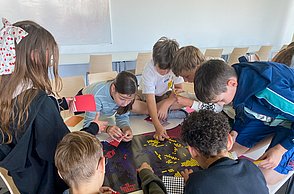 Kinder kleben mit Punkten Bilder von Einstein und Marie Curie