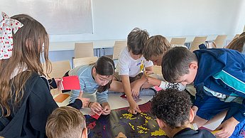 Kinder kleben mit Punkten Bilder von Einstein und Marie Curie