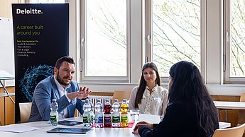 Vertreter der Firma Deloitte im Gespräch mit einer Studentin