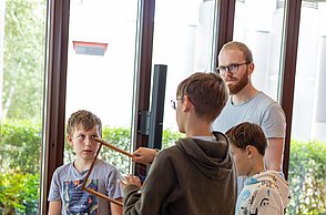 Kinder bauen eine Bienenbeute auf.