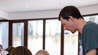 Kinder schauen sich Bienenwaben und Utensilien zur Imkerei an.
