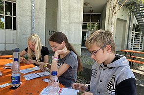Kinder schreiben etwas auf Zettel