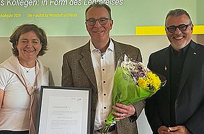 Preisträger Prof. Dr. Robert Nothhelfer mit Urkunde und Blumenstrauß, rechts neben ihm steht Prof. Dr. Thomas Cleff