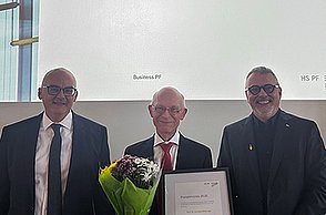 Preisträger Prof. Dr. Andreas Willburger mit Urkunde und Blumenstrauß, links davon Prof. Anush Tavakoli, rechts Prof. Dr. Thomas Cleff