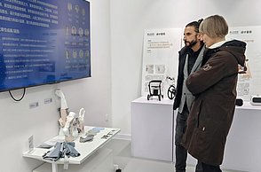 Cosima Striepe und Stefan Barth im Ausstellungsraum der Hunan School of Design, wo aktuelle Projekte präsentiert werden.