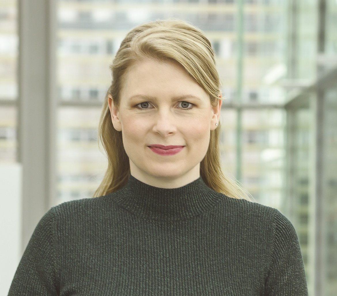 Frau mittleren Alters, mit blonden Haaren, schaut in die Kamera.