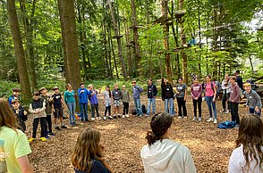 Kinder machen eine Teamübung im Waldklettergarten