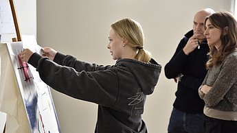 Personen betrachten Leinwand auf einer Staffelei