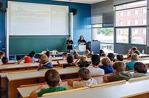 Kinder mit Studenten im Austausch.