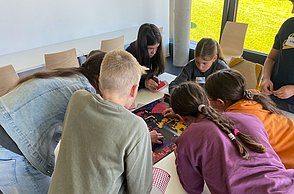 Kinder kleben mit Punkten Bilder von Einstein und Marie Curie