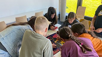 Kinder kleben mit Punkten Bilder von Einstein und Marie Curie