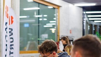 Studierende an einem Tisch, die Unterlagen betrachten