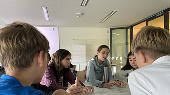 Kinder disskutieren in der Gruppe die Ergebnisse zum Thema Treibhaus-Kompass