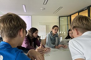 Kinder disskutieren in der Gruppe die Ergebnisse zum Thema Treibhaus-Kompass