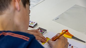 Ein Junge beschriftet seinen Pen and Paper Computer