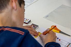 Ein Junge beschriftet seinen Pen and Paper Computer