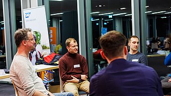 Personen im Gespräch in einem Stuhlkreis
