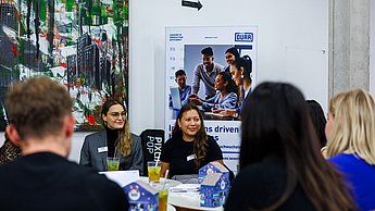 Zwei Frauen am Tisch mit Studierenden