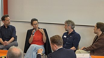 Eine Diskussionsrunde zwischen vier Referenten.