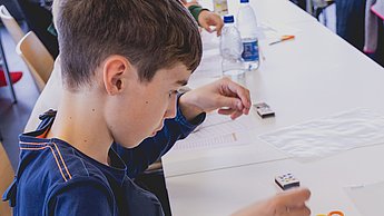 Ein Junge erkundet seinen Pen and Paper Computer