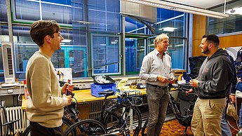 Menschen, die sich während der Laborführung an der Fakultät für Technik neugierig umsehen und unterhalten
