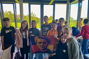 Die erste Gruppe an Kindern präsentiert ihr Bild von Marie Curie