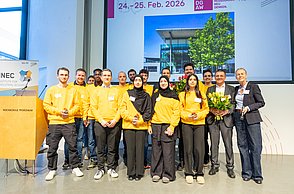 Gruppenfoto von jungen Menschen in gelben Sweatshirts und Jörg Woidasky mit Blumenstrauß