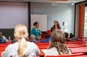 Workshopsituation: Kinder sitzen auf Plätzen und schreiben.